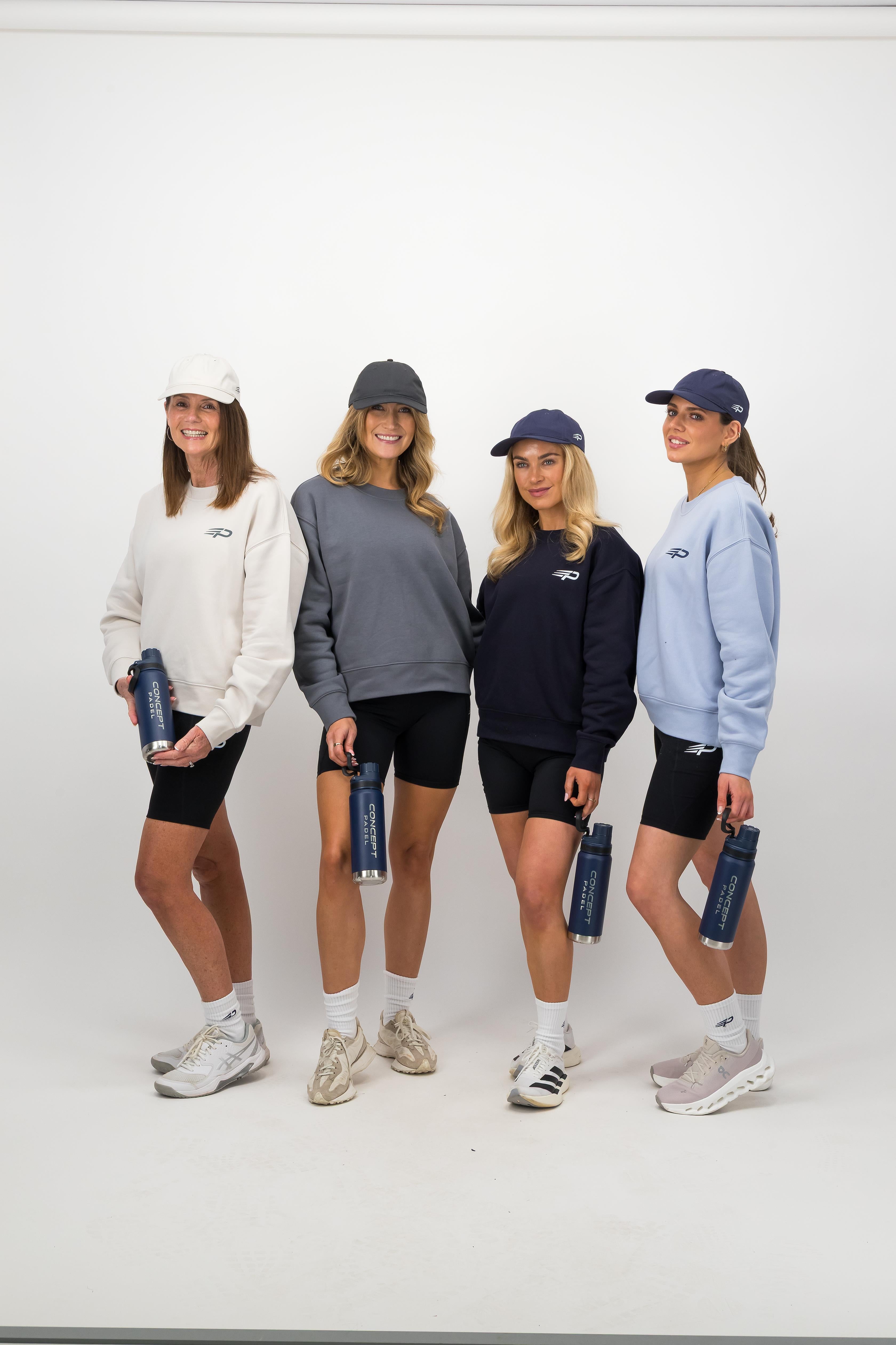 Group of women in athletic wear holding navy Concept Padel water bottles against a white background
