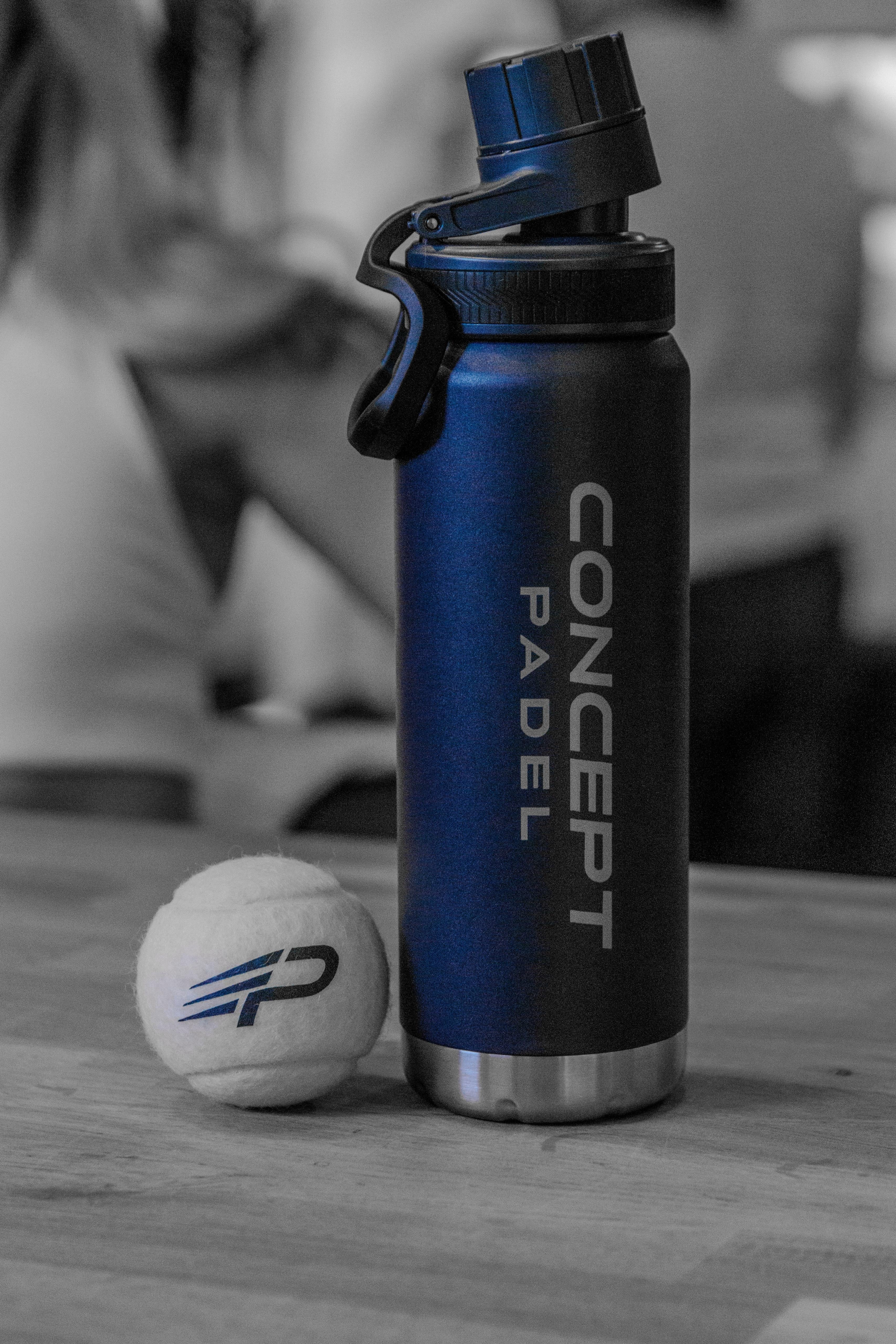 Blue Concept Padel water bottle with a paddle ball on a wooden surface
