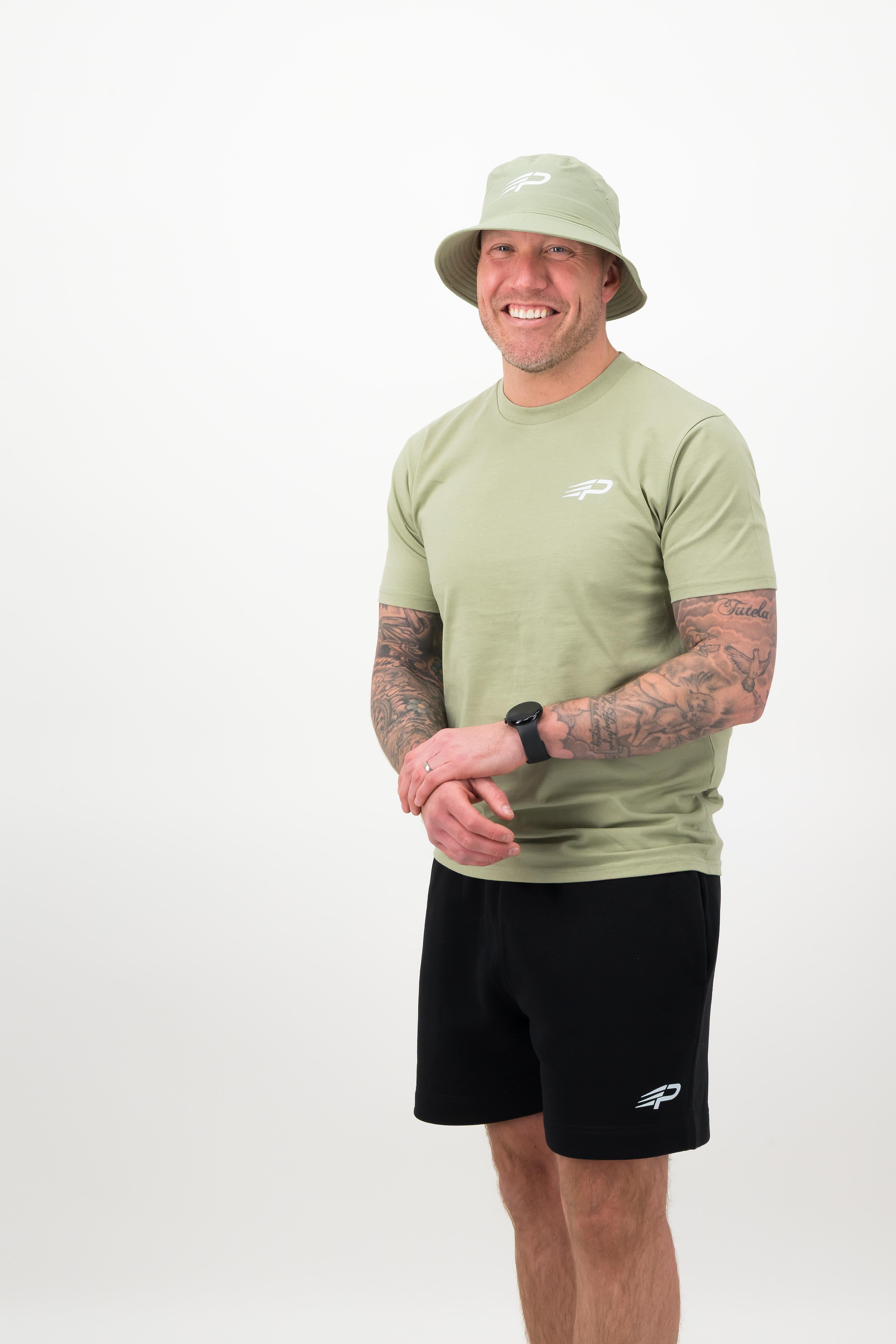 Man wearing pistachio bucket hat with matching pistachio tee and black shorts