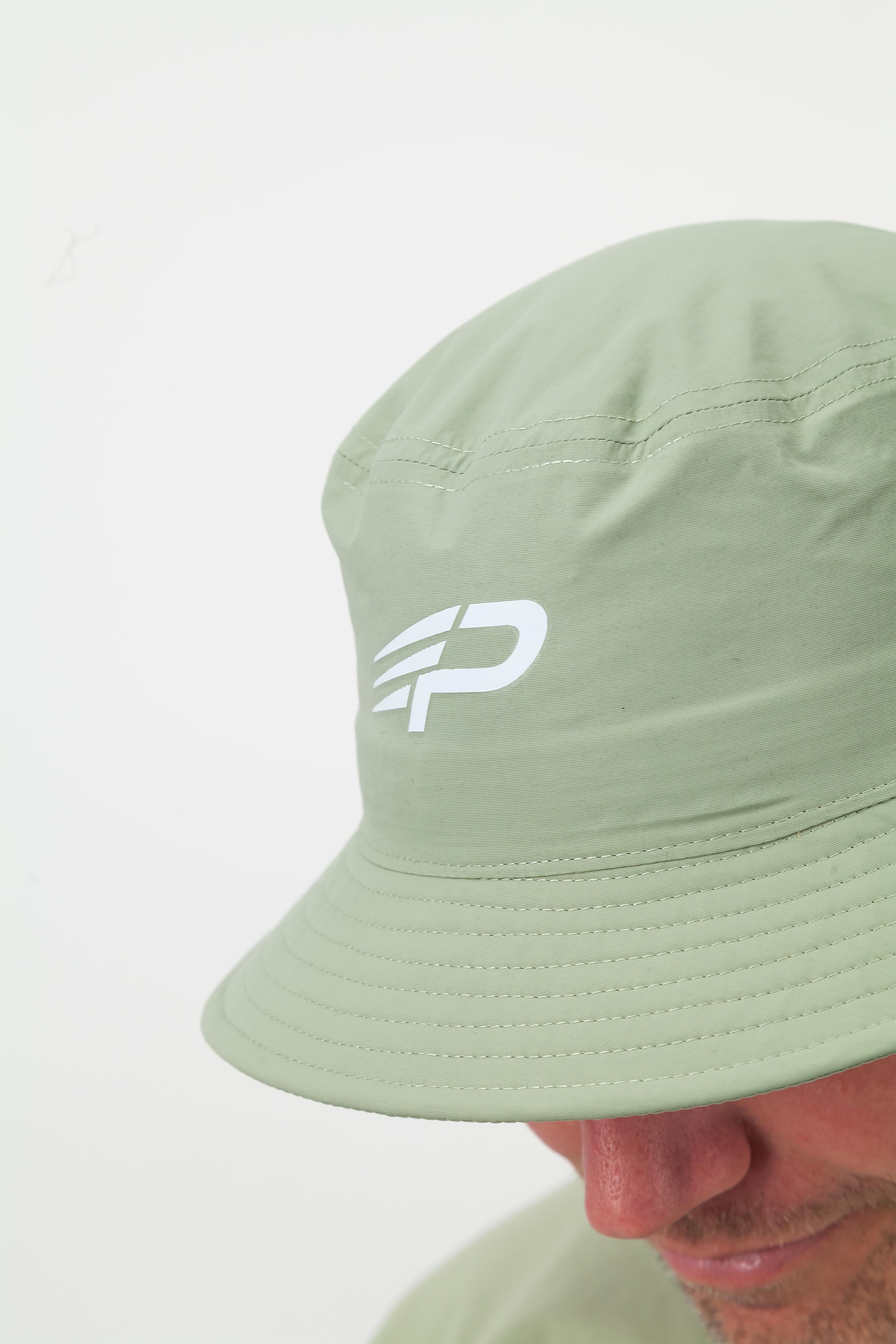 Close up of pistachio Concept Padel bucket hat with white logo