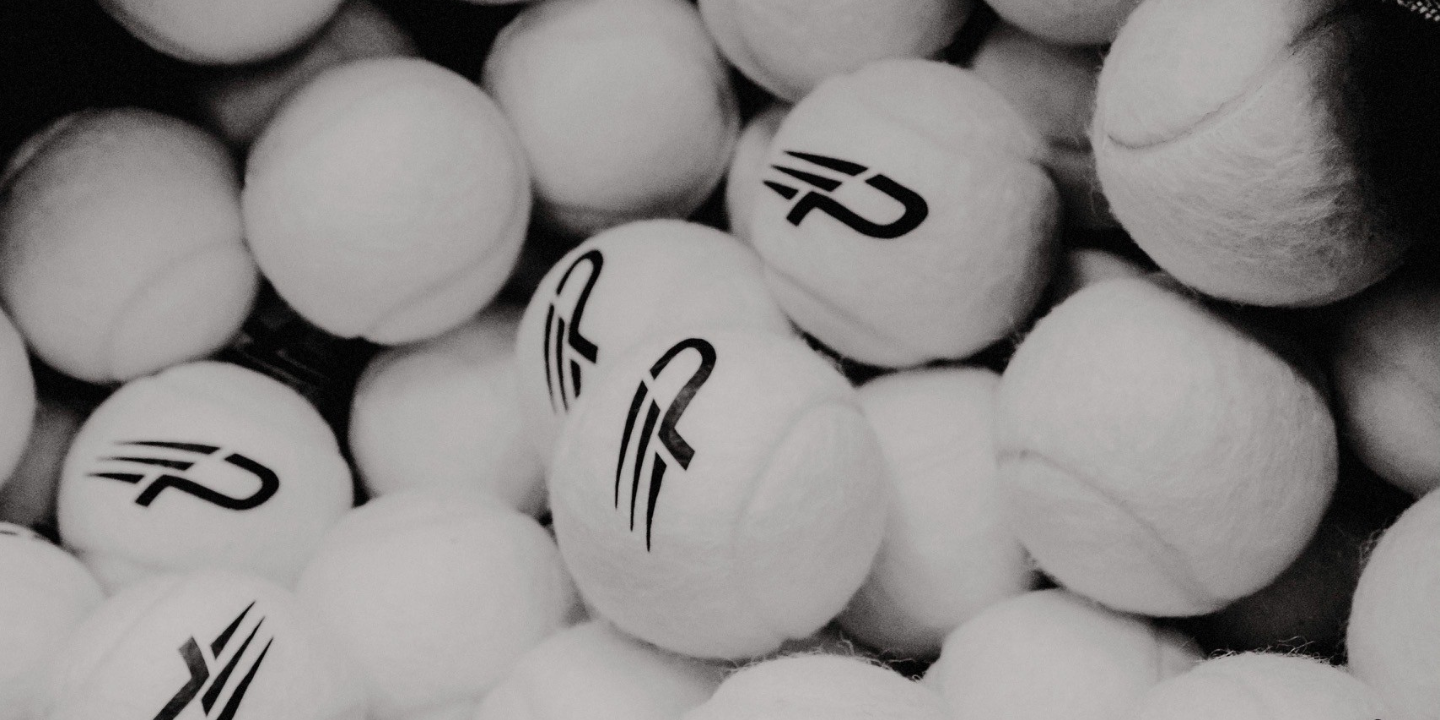 Collection of white tennis balls with a concept padel logo on a black background