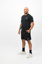 Person wearing Concept Padel black performance shorts standing facing forward, styled with black tee and trainers against a white background