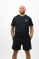 Person wearing Concept Padel black performance shorts standing facing forward, styled with black tee and trainers against a white background