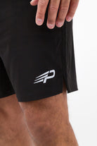 Close‑up of the Concept Padel logo on the black performance shorts worn against a white background