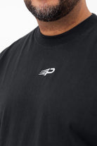Close‑up of the Concept Padel logo on the black faded tee worn against a white background