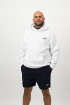 Person wearing a Concept Padel white rebound hoodie standing facing forward, styled with black shorts and trainers against a white background