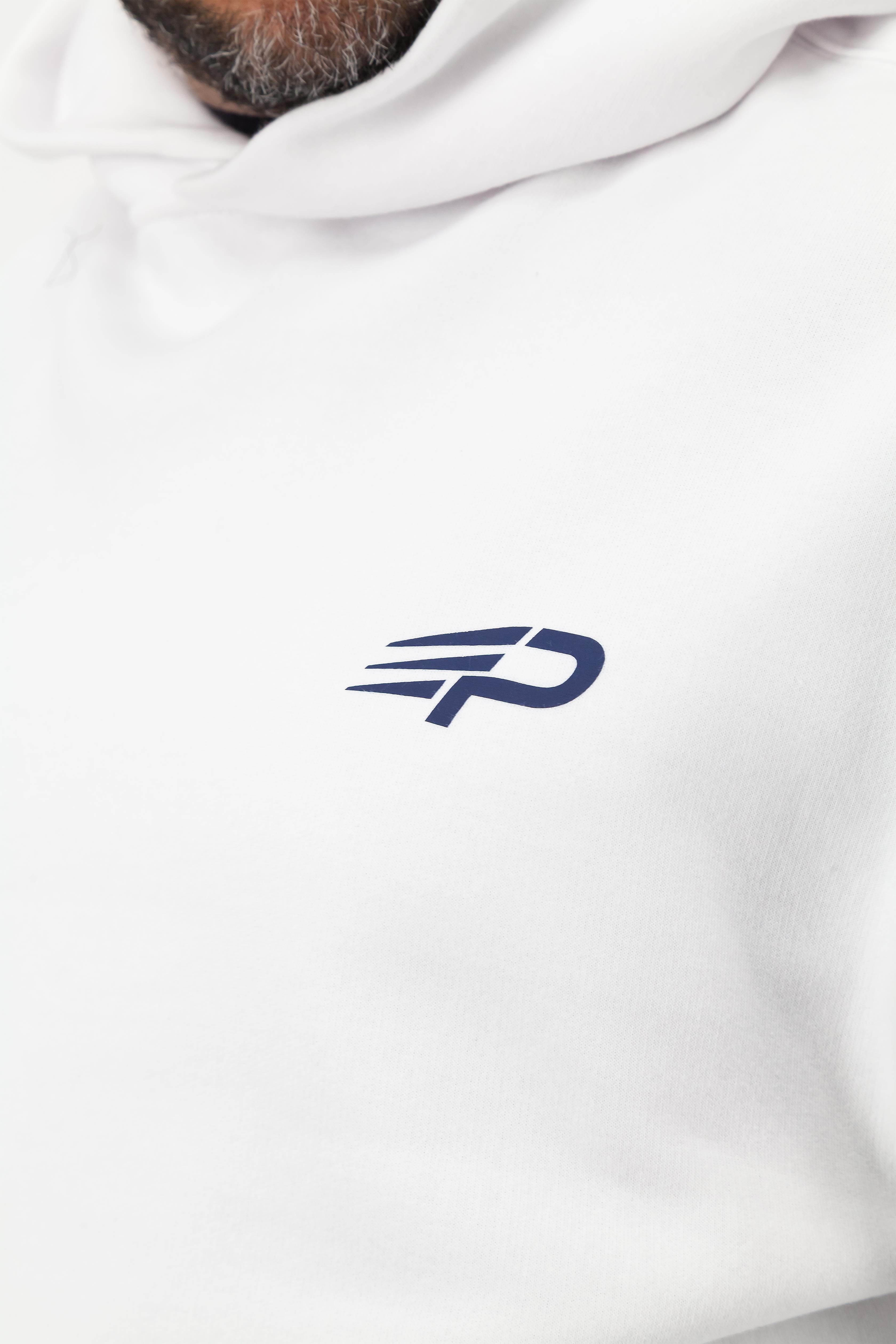 Close‑up of the Concept Padel logo on the white rebound hoodie worn against a white background