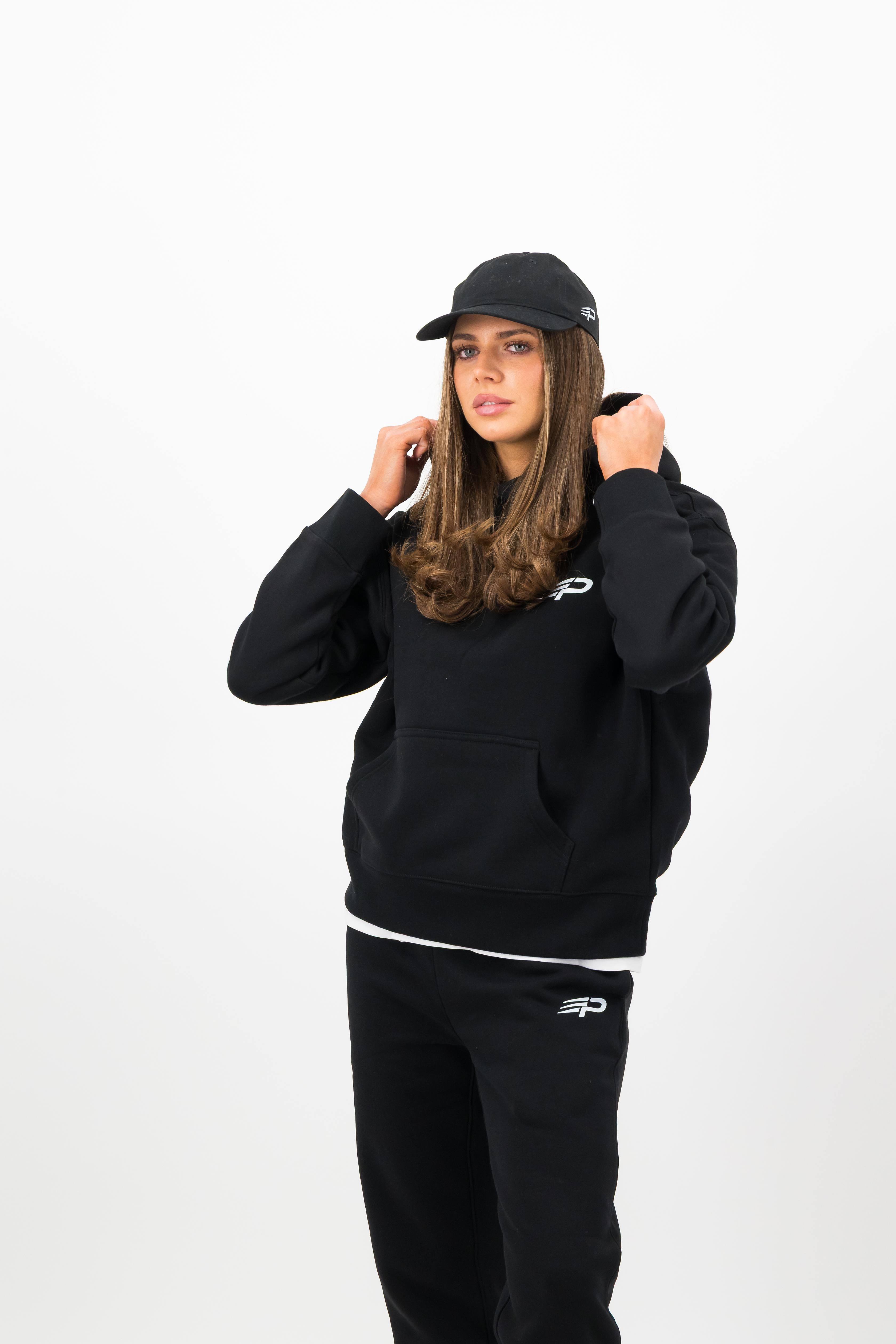 Back view of woman wearing black Concept Padel cap and black sweatshirt