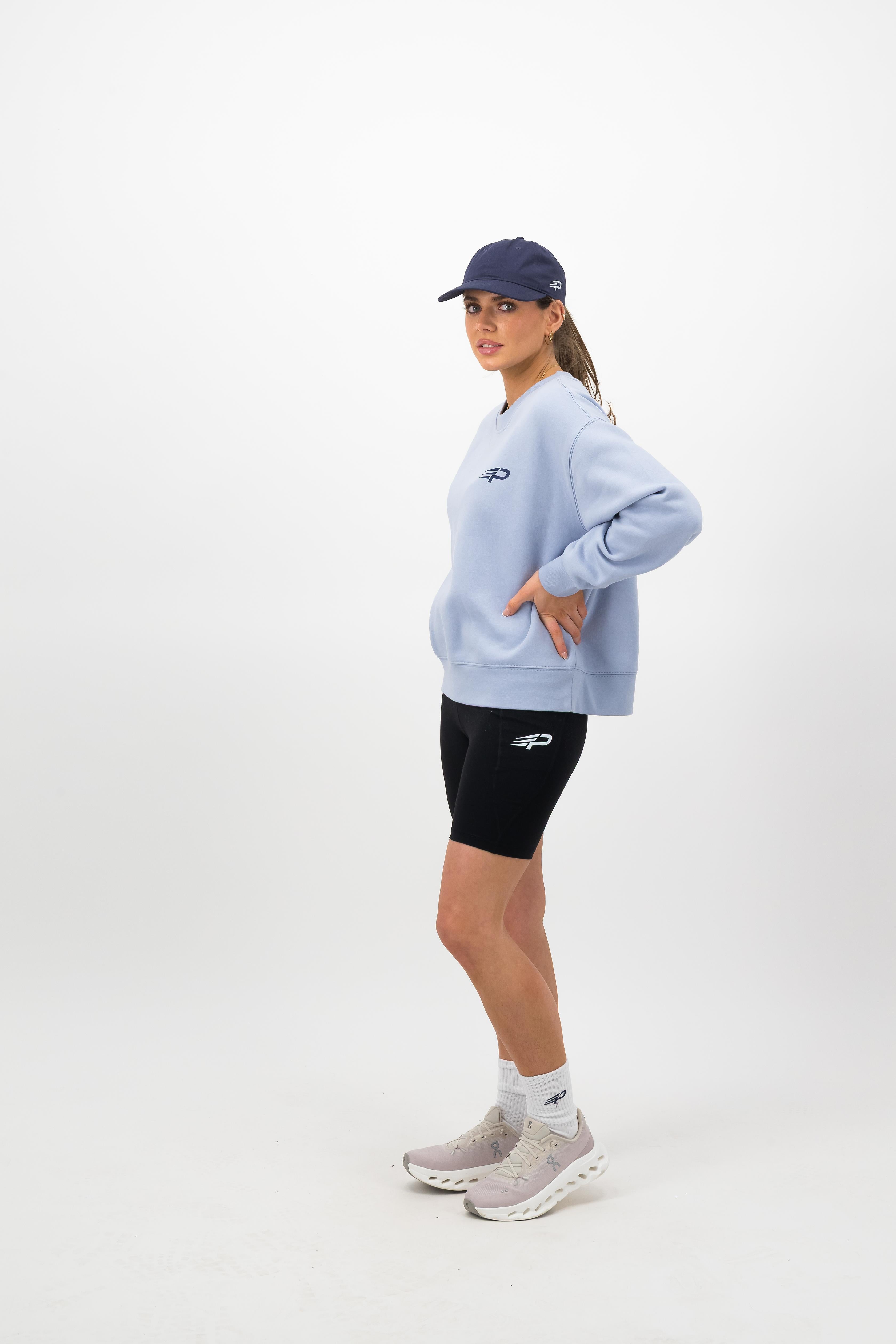 Side view of midnight blue Concept Padel cap styled with casual athletic outfit