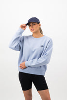 Front view of a Woman wearing midnight blue Concept Padel cap with oversized sweatshirt