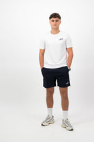 Person wearing a Concept Padel white performance tee standing facing forward, styled with dark shorts and trainers against a white background
