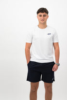 Person wearing a Concept Padel white performance tee standing facing forward, styled with dark shorts and trainers against a white background