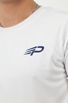 Close‑up of the Concept Padel logo on the white performance tee worn against a white background