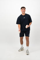 Person wearing Concept Padel ink blue performance shorts throwing padel balls, paired with ink blue tee and trainers against a white background