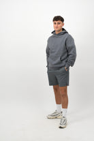 Person wearing a Concept Padel shadow rebound hoodie standing facing forward, styled with grey shorts and trainers against a white background