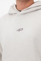 Close‑up of the Concept Padel logo on the bone faded hoodie worn against a white background