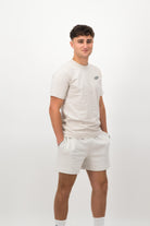 Person wearing a Concept Padel bone rebound tee standing side on, paired with white shorts and trainers against a white background