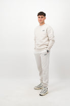 Person wearing Concept Padel bone rebound sweatpants standing side on, paired with matching sweatshirt and trainers against a white background