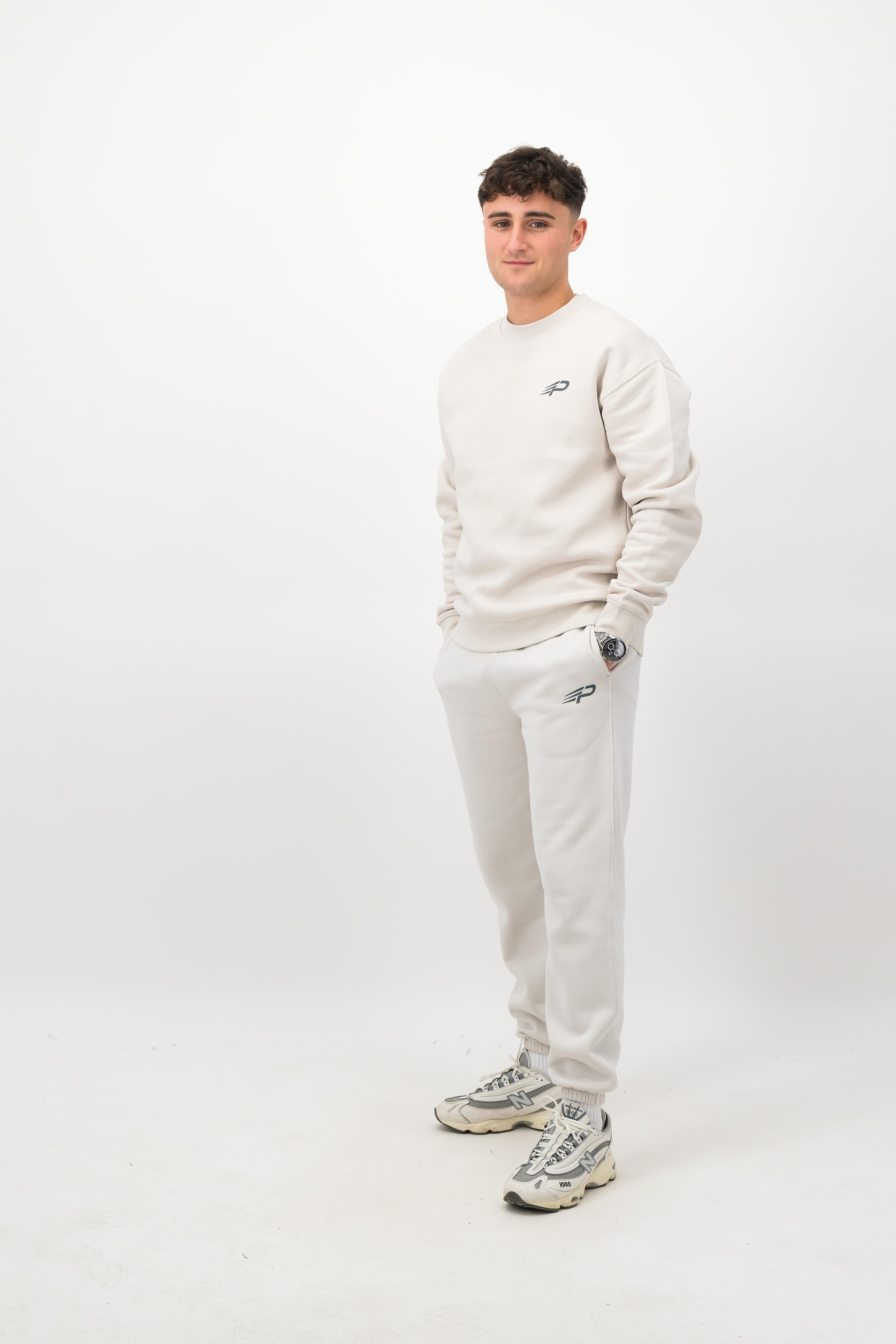 Person wearing Concept Padel bone rebound sweatpants standing side on, paired with matching sweatshirt and trainers against a white background