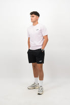 Person wearing a Concept Padel orchid rebound tee standing side on, paired with black shorts and trainers against a white background