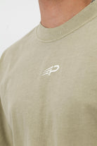 Close‑up of the Concept Padel logo on the eucalyptus faded tee worn against a white background
