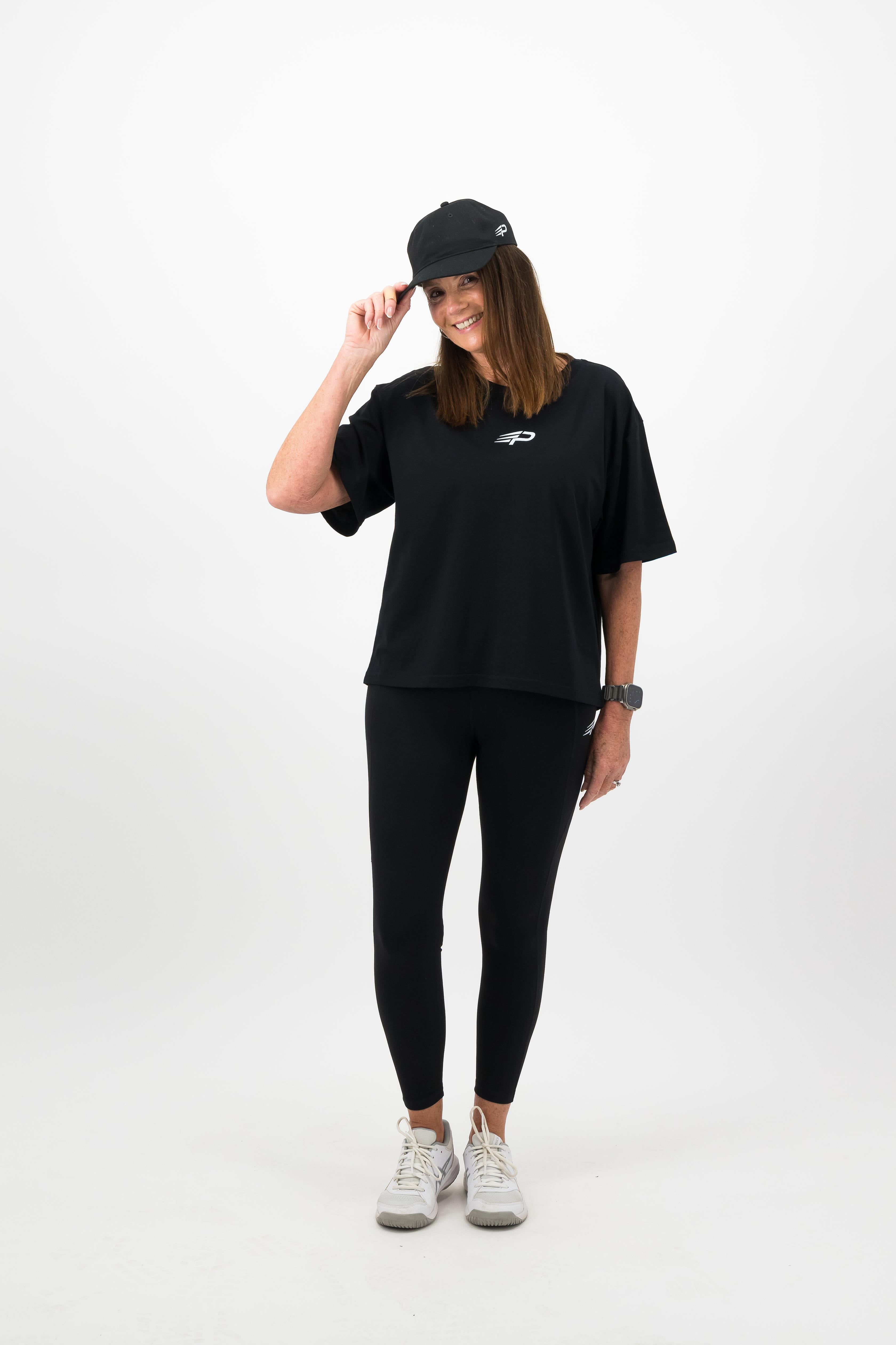 Woman wearing black Concept Padel cap with full black outfit
