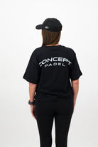 Side view of woman wearing black Concept Padel cap