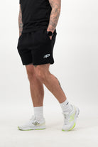 Lower‑leg view showing white Concept Padel everyday socks, black shorts and white trainers