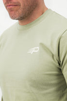 Close‑up of the Concept Padel logo on the pistachio rebound tee worn against a white background