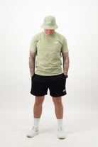 Man wearing pistachio bucket hat with matching pistachio tee and black shorts