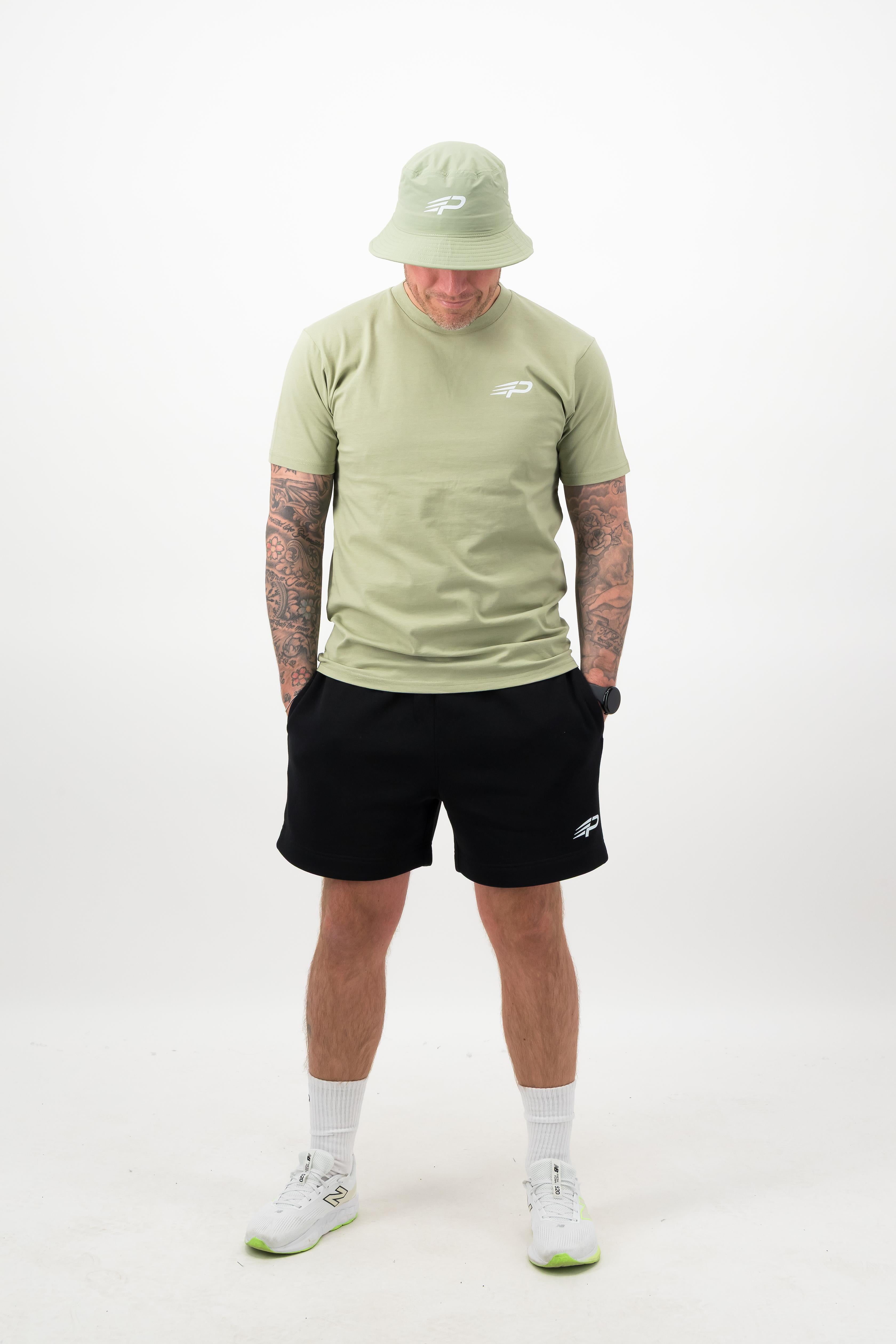 Man wearing pistachio bucket hat with matching pistachio tee and black shorts