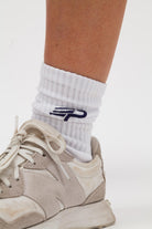 White Concept Padel women’s everyday sock with blue logo worn with beige trainers
