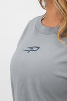 Close‑up of the Concept Padel logo on the storm court tee worn by a woman against a white background