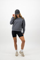 Woman wearing coal Concept Padel cap with grey sweatshirt and shorts