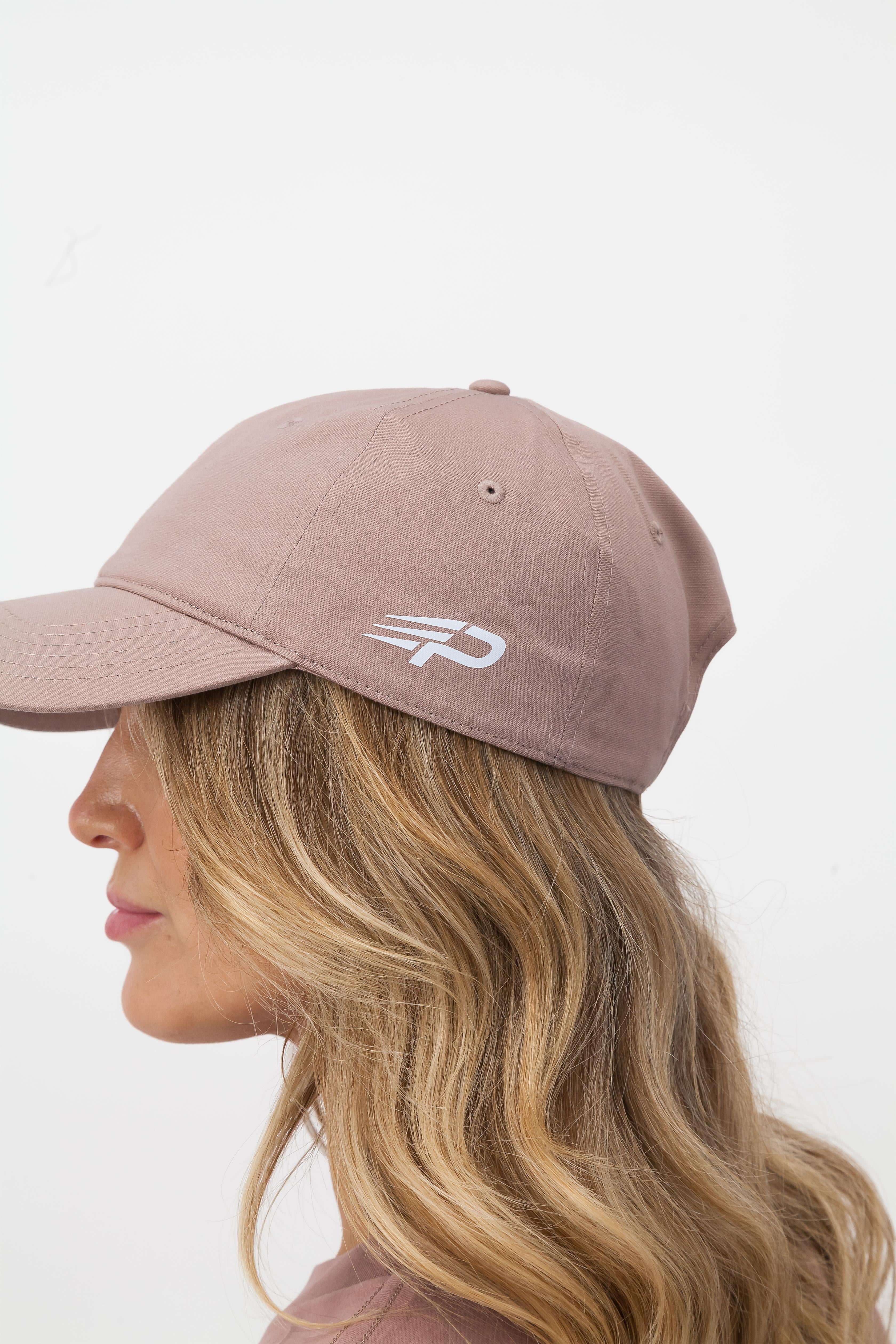 Woman wearing hazy pink Concept Padel cap